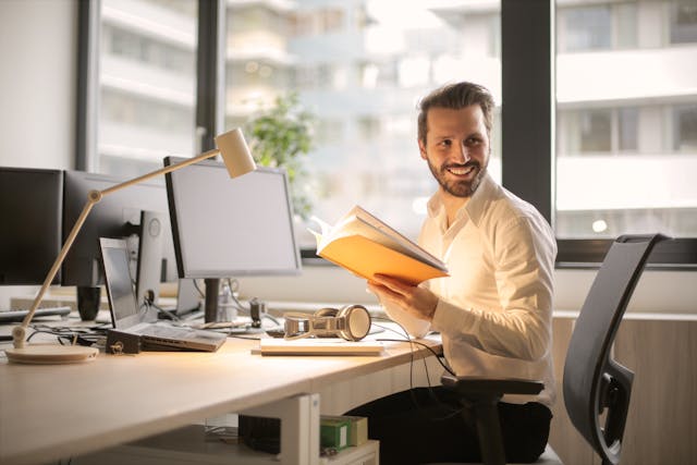 Man reading recommendations by computer and smiling